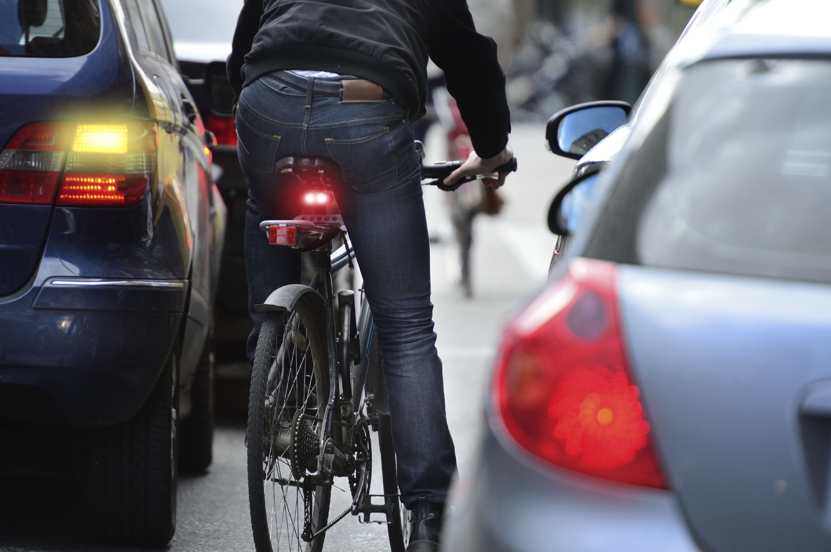 Photo of a cyclist next to cars